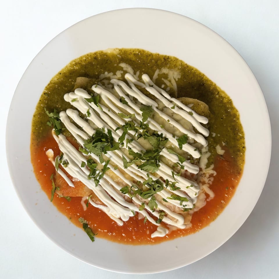La Reyna Xpress enchiladas with green and red sauce, drizzled with crema and cilantro.